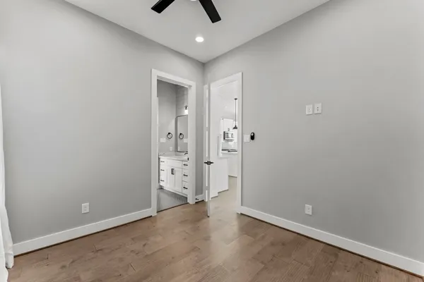 a view of an empty room with a ceiling fan and window