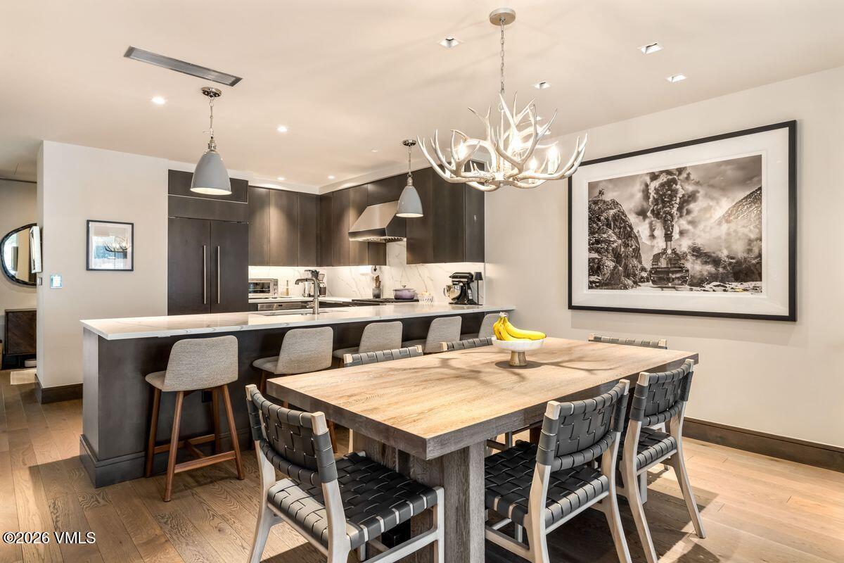 430 South Frontage Road East, Unit RU303 Vail, CO 81657 - Photo 3 of 39 a view of a dining room with furniture wooden floor and chandelier