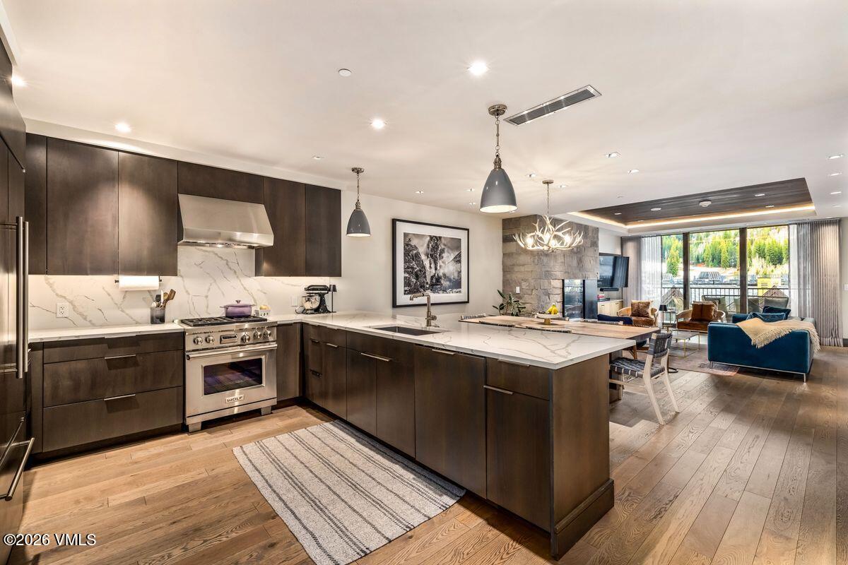 430 South Frontage Road East, Unit RU303 Vail, CO 81657 - Photo 6 of 39 a large kitchen with stainless steel appliances granite countertop a stove and a view of living room