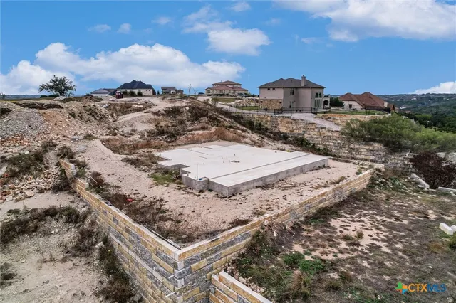 a view of a dry yard with wooden fence