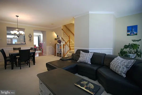 a living room with furniture a dining table and a chandelier