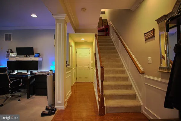 a view of a hallway with workspace and wooden floor