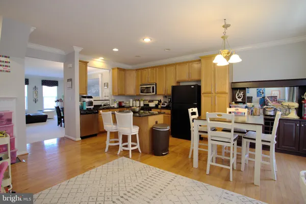 a dining room with stainless steel appliances kitchen island granite countertop a dining table chairs and granite counter tops