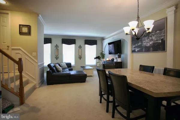 a living room with couches a dining table and chairs with wooden floor