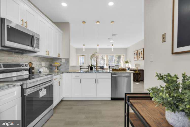 44 Buttonwood Street Mount Holly, NJ 08060 - Photo 11 of 31 a kitchen with white cabinets and stainless steel appliances
