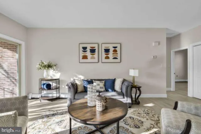 a living room with furniture two window and a table