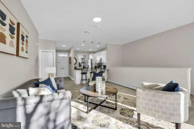 a living room with furniture and view of kitchen