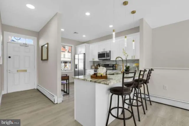 a kitchen with stainless steel appliances kitchen island granite countertop a refrigerator and a stove top oven