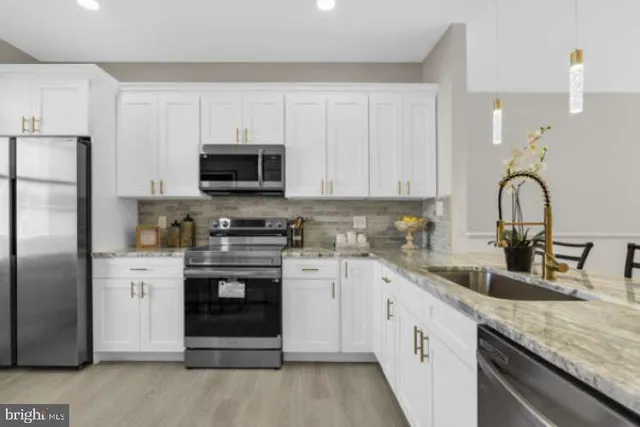 a kitchen with stainless steel appliances granite countertop a stove a sink and a refrigerator