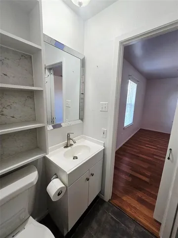 a spacious bathroom with a toilet sink and mirror