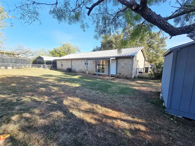 a view of a house with backyard and sitting area