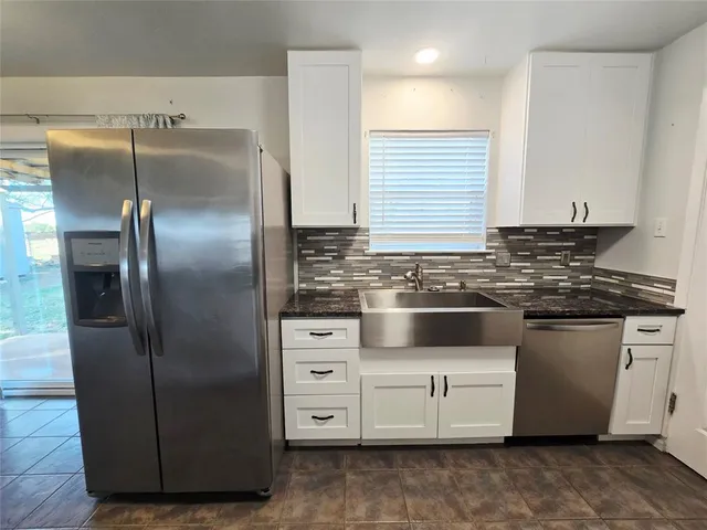 a kitchen with granite countertop a refrigerator and a stove