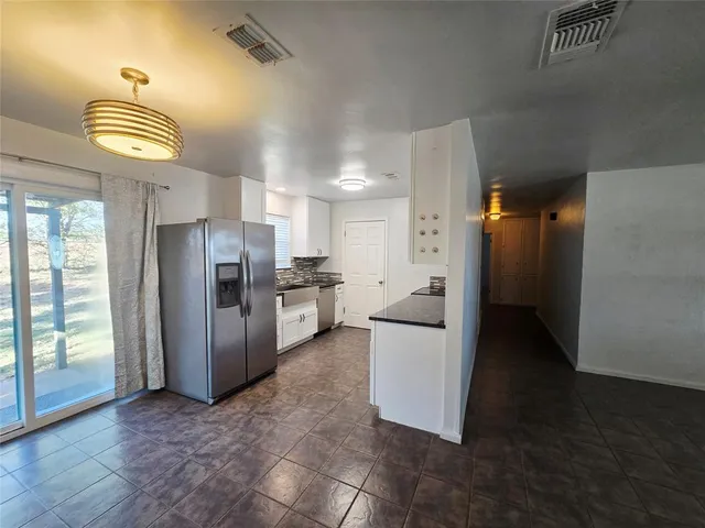 a kitchen with stainless steel appliances a refrigerator and a stove top oven