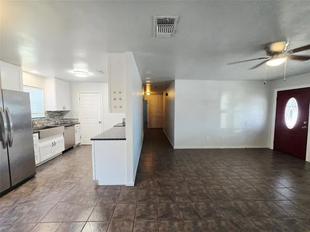 a view of a kitchen with a sink and refrigerator