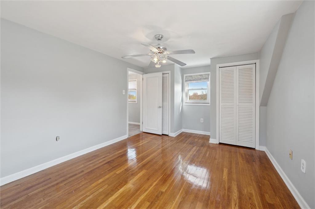2936 Brodhead Road Aliquippa, PA 15001 - Photo 23 of 47 an empty room with wooden floor chandelier fan and windows