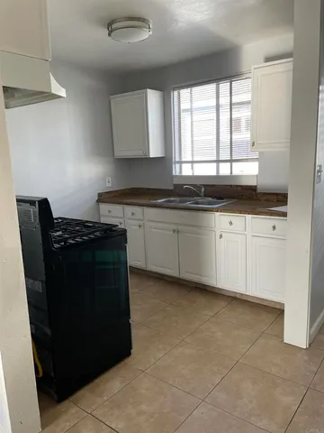 a kitchen with granite countertop a sink a counter space and cabinets