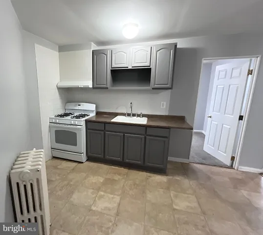 a kitchen with stainless steel appliances a sink stove and cabinets