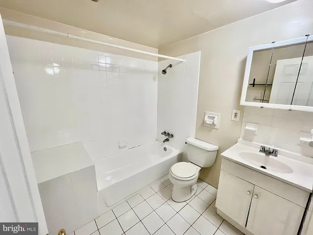 a bathroom with a bathtub shower sink vanity and toilet