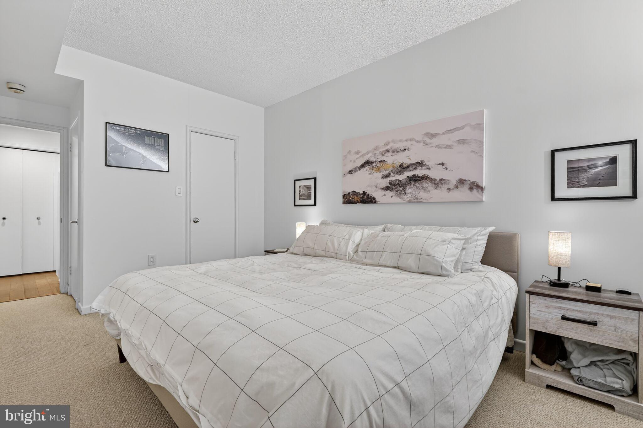 1045 31st Street Northwest, Unit 21 Washington, DC 20007 - Photo 14 of 35 a bedroom with a bed and a lamp on dresser