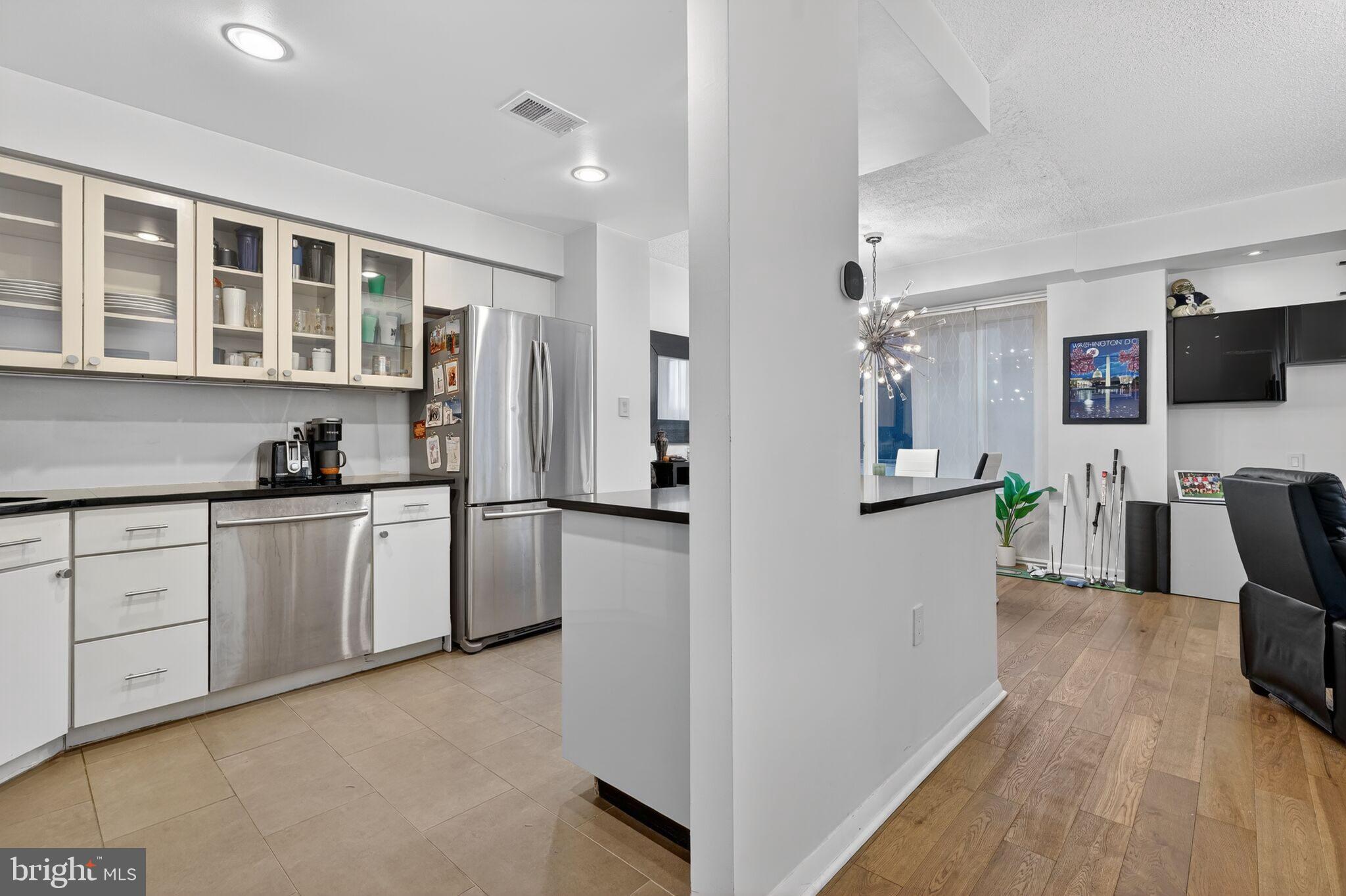 1045 31st Street Northwest, Unit 21 Washington, DC 20007 - Photo 4 of 35 a kitchen with stainless steel appliances granite countertop a refrigerator and a stove top oven