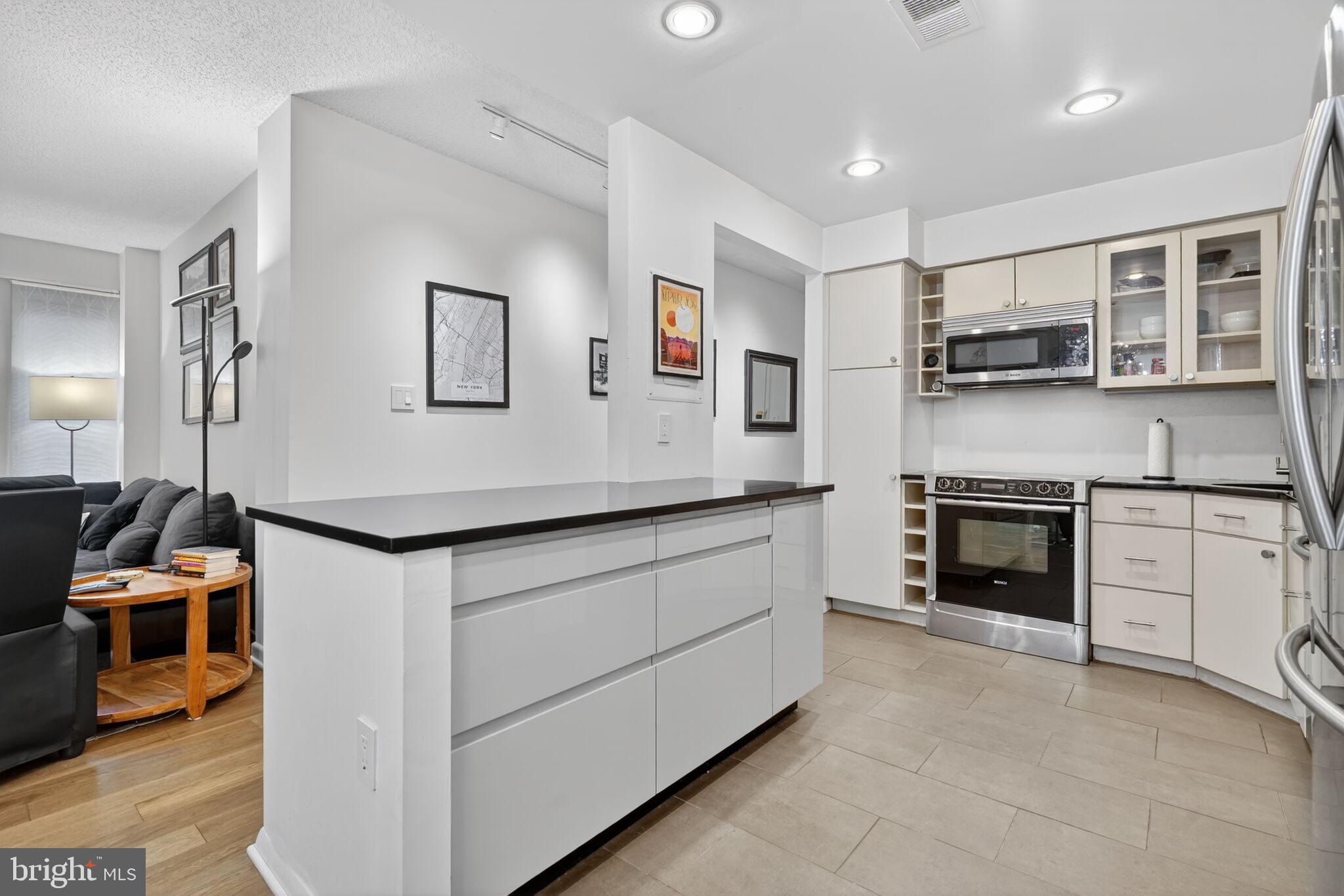 1045 31st Street Northwest, Unit 21 Washington, DC 20007 - Photo 5 of 35 a kitchen with cabinets and a fireplace