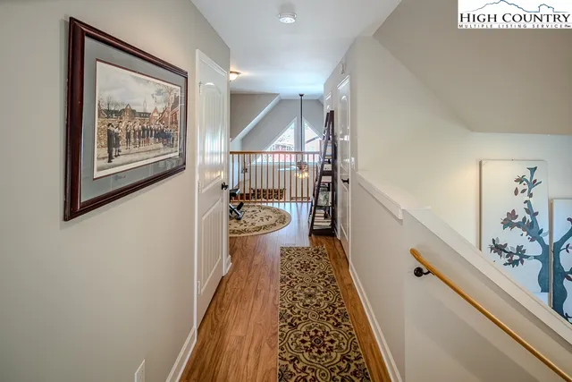 a view of a hallway with wooden floor and staircase