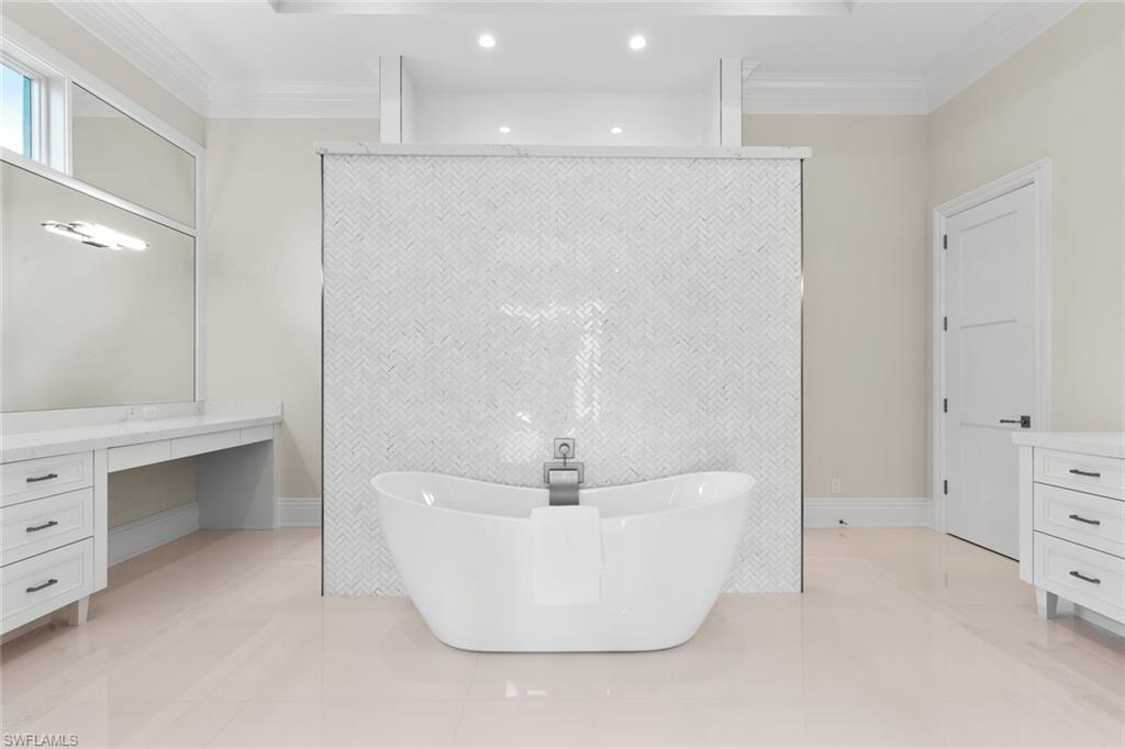 1670 Crayton Road Naples, FL 34102 - Photo 13 of 26 a white bath tub sitting in a bathroom