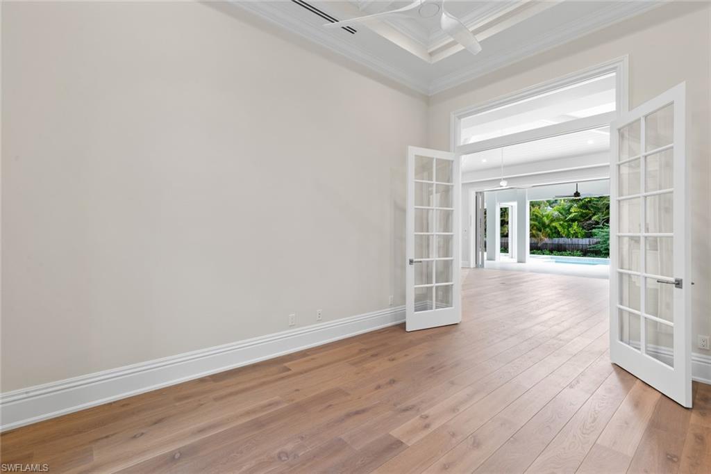 1670 Crayton Road Naples, FL 34102 - Photo 19 of 26 an empty room with wooden floor and windows