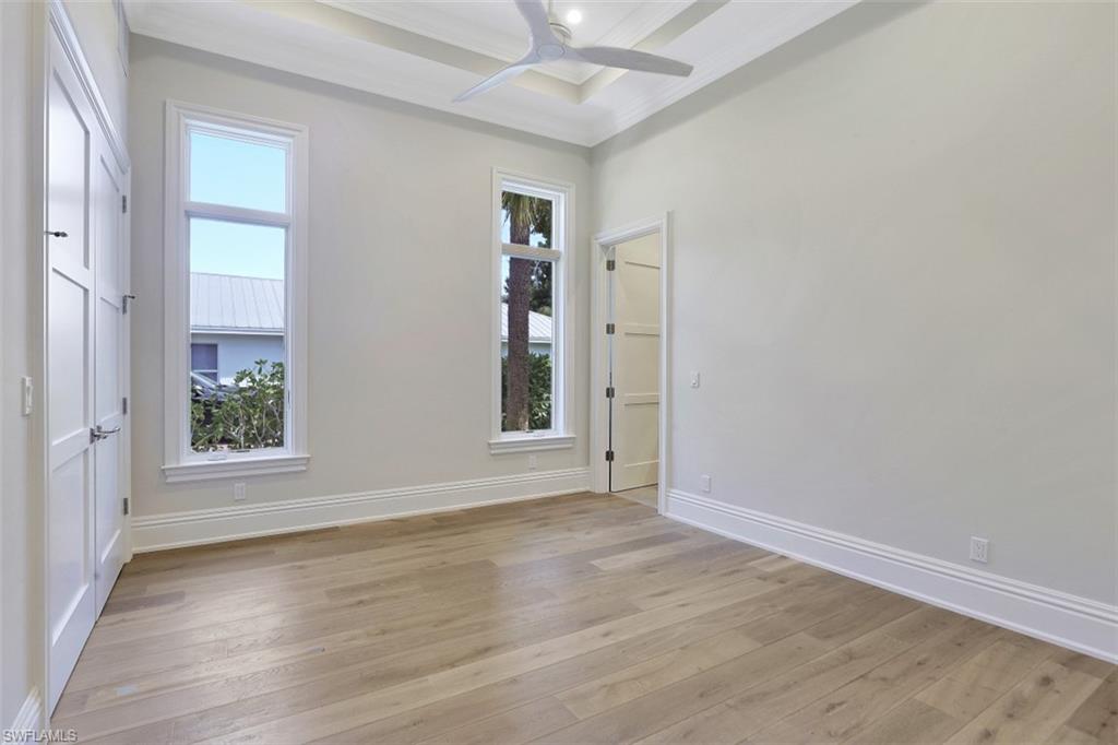 1670 Crayton Road Naples, FL 34102 - Photo 24 of 26 an empty room with wooden floor and windows