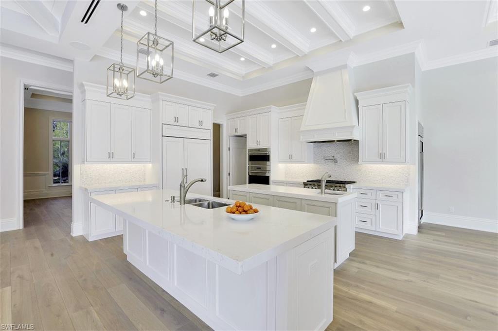 1670 Crayton Road Naples, FL 34102 - Photo 8 of 26 a kitchen with stainless steel appliances white cabinets a sink dishwasher and a stove with wooden floor