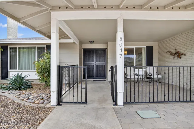 a view of a patio with table and chairs and wooden fence