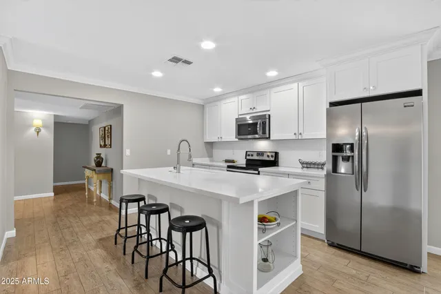a kitchen with stainless steel appliances a stove microwave and sink