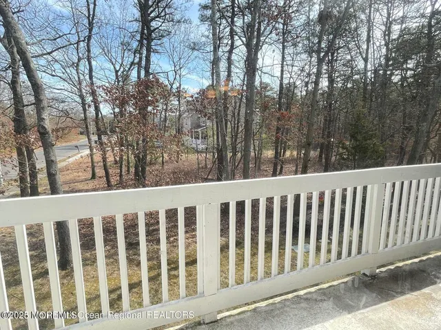 a view of a room with wooden floor chandelier and windows