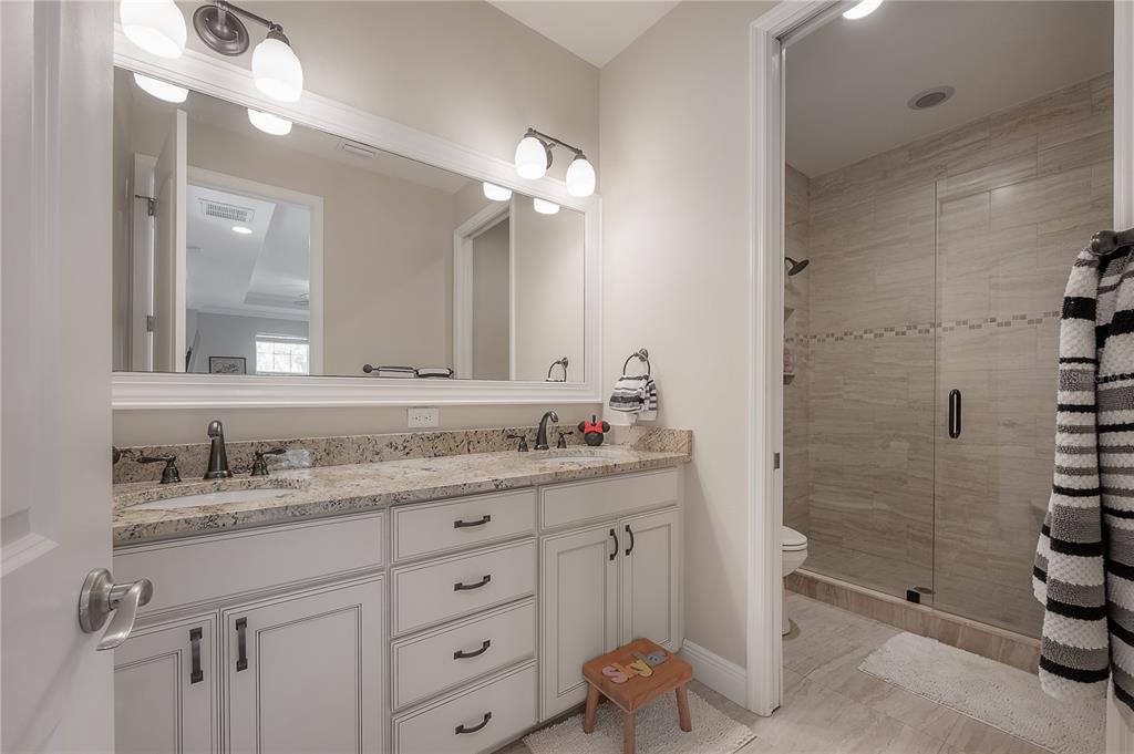 3108 West Villa Rosa Street Tampa, FL 33611 - Photo 42 of 58 a bathroom with a granite countertop sink a mirror and a shower