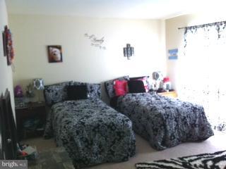 5758 Village Green Drive, Unit E Alexandria, VA 22309 - Photo 5 of 7 a bedroom with a bed and a couch