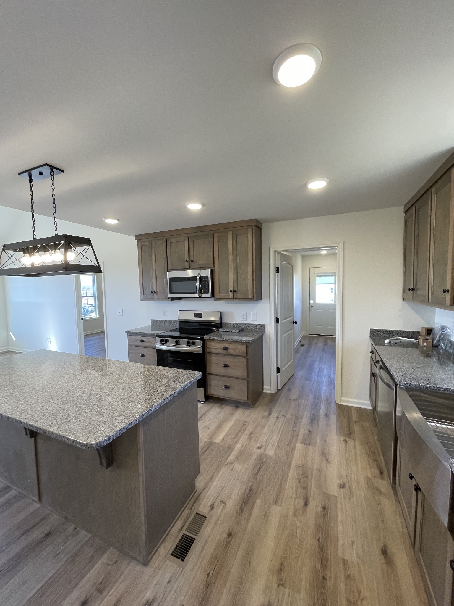 586 Pleasant Hill Road Lafayette, TN 37083 - Photo 11 of 38 a kitchen with stainless steel appliances granite countertop wooden cabinets a stove top oven a sink dishwasher and wooden floor