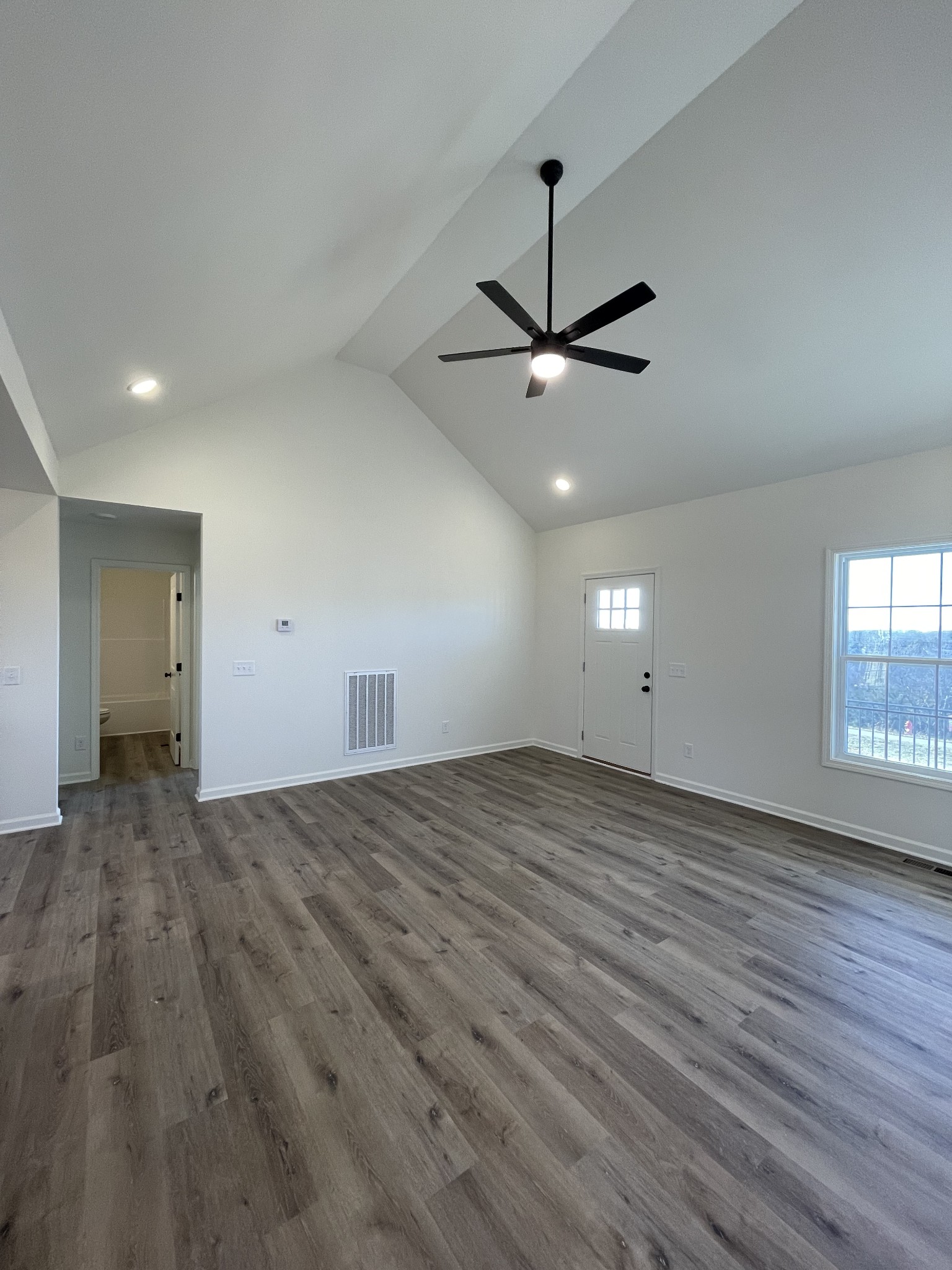 586 Pleasant Hill Road Lafayette, TN 37083 - Photo 14 of 38 an empty room with wooden floor ceiling fan and windows