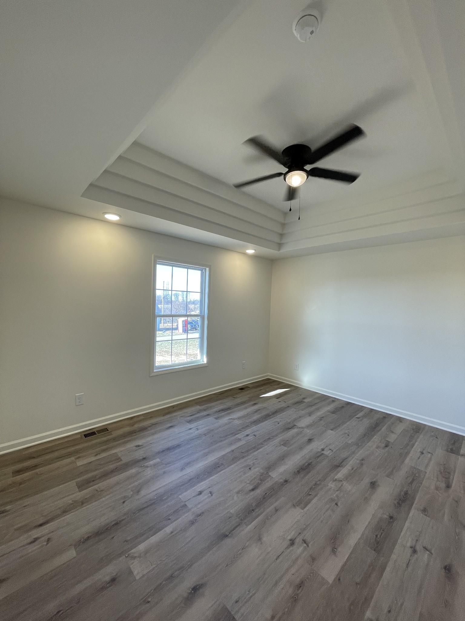586 Pleasant Hill Road Lafayette, TN 37083 - Photo 15 of 38 an empty room with wooden floor fan and windows