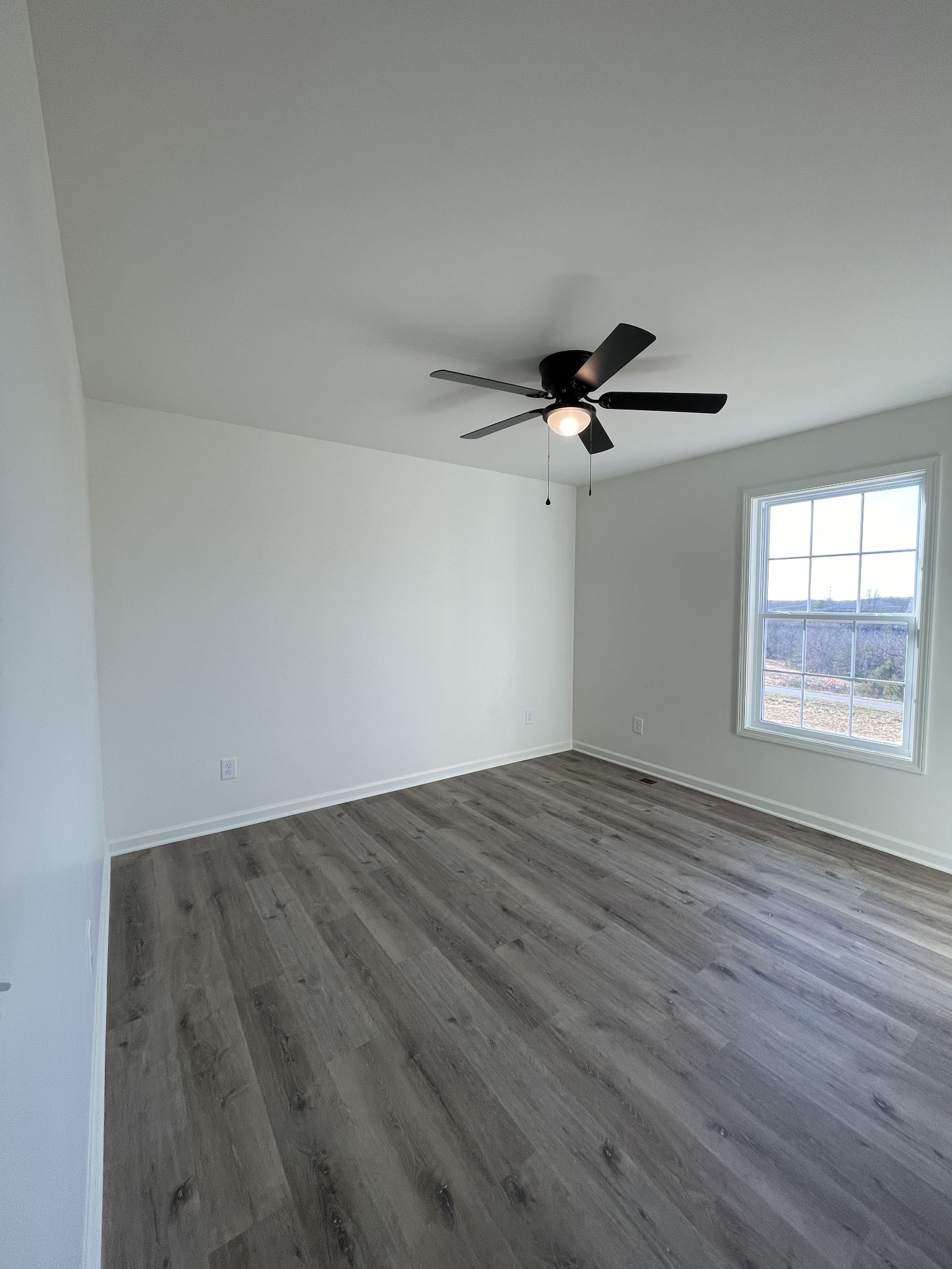 586 Pleasant Hill Road Lafayette, TN 37083 - Photo 25 of 38 a view of empty room with wooden floor and fan