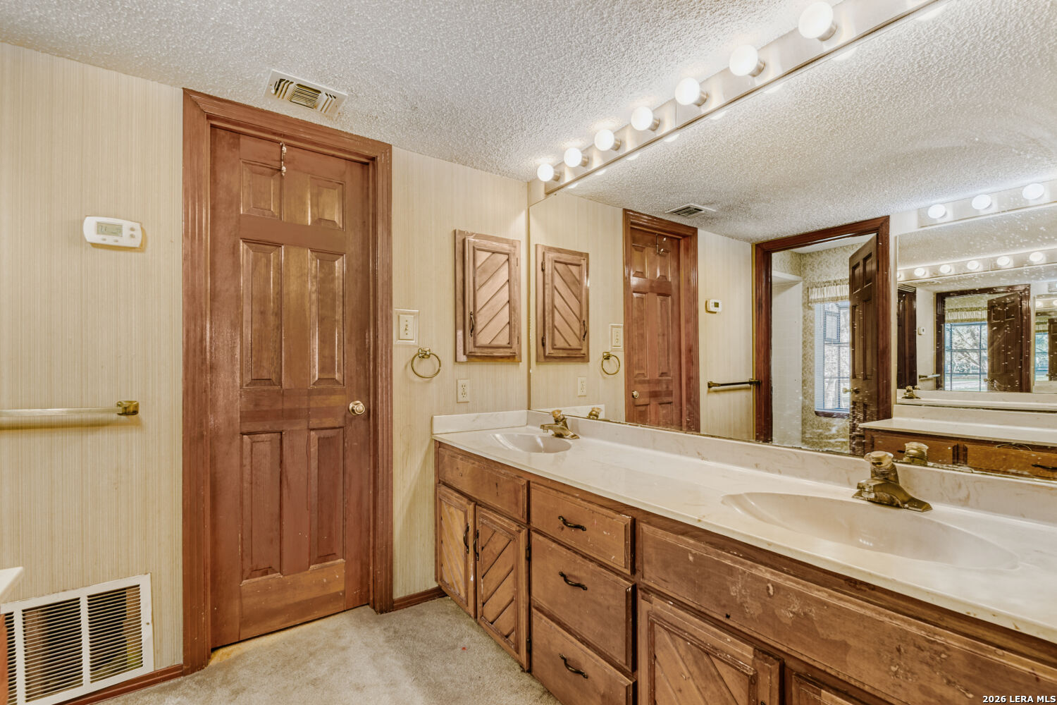 29342 Seabiscuit Drive Fair Oaks Ranch, TX 78015 - Photo 11 of 45 a bathroom with a double vanity sink a mirror and a shower