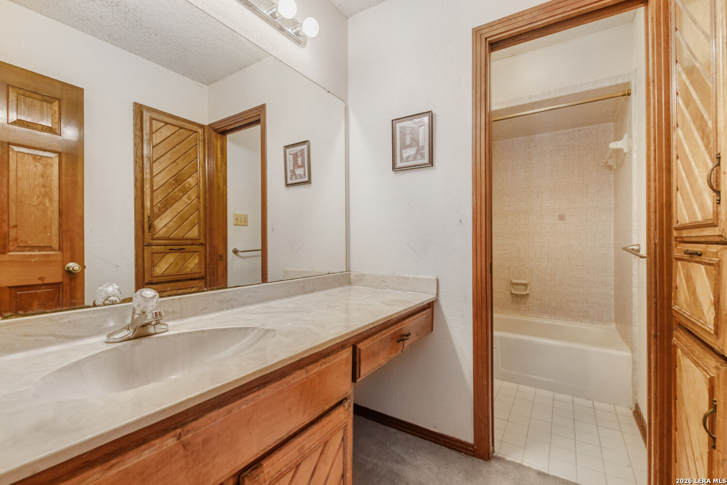 29342 Seabiscuit Drive Fair Oaks Ranch, TX 78015 - Photo 19 of 45 a bathroom with a granite countertop sink a mirror and a bathtub