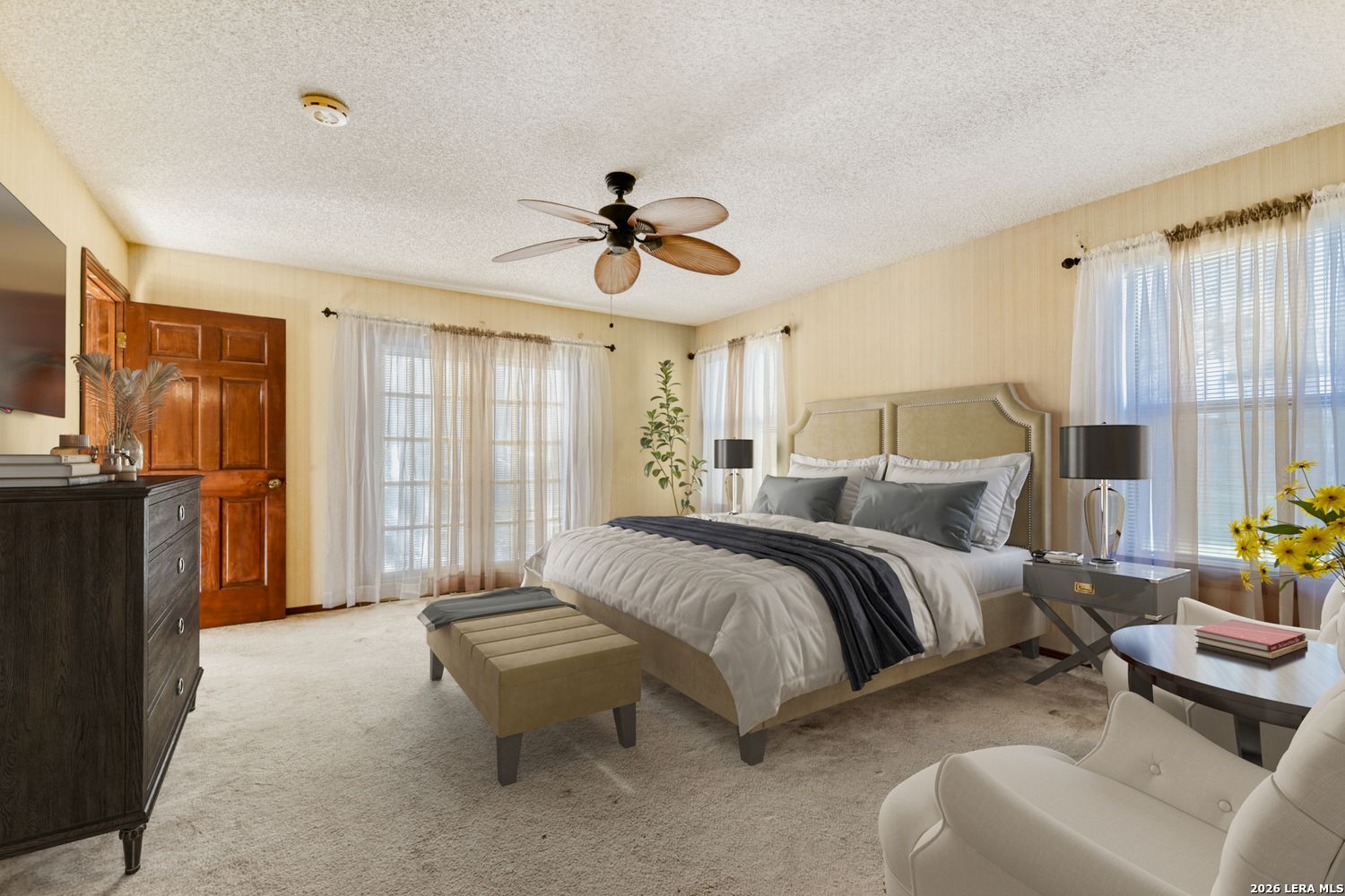 29342 Seabiscuit Drive Fair Oaks Ranch, TX 78015 - Photo 10 of 45 a spacious bedroom with a bed a couch and a chandelier