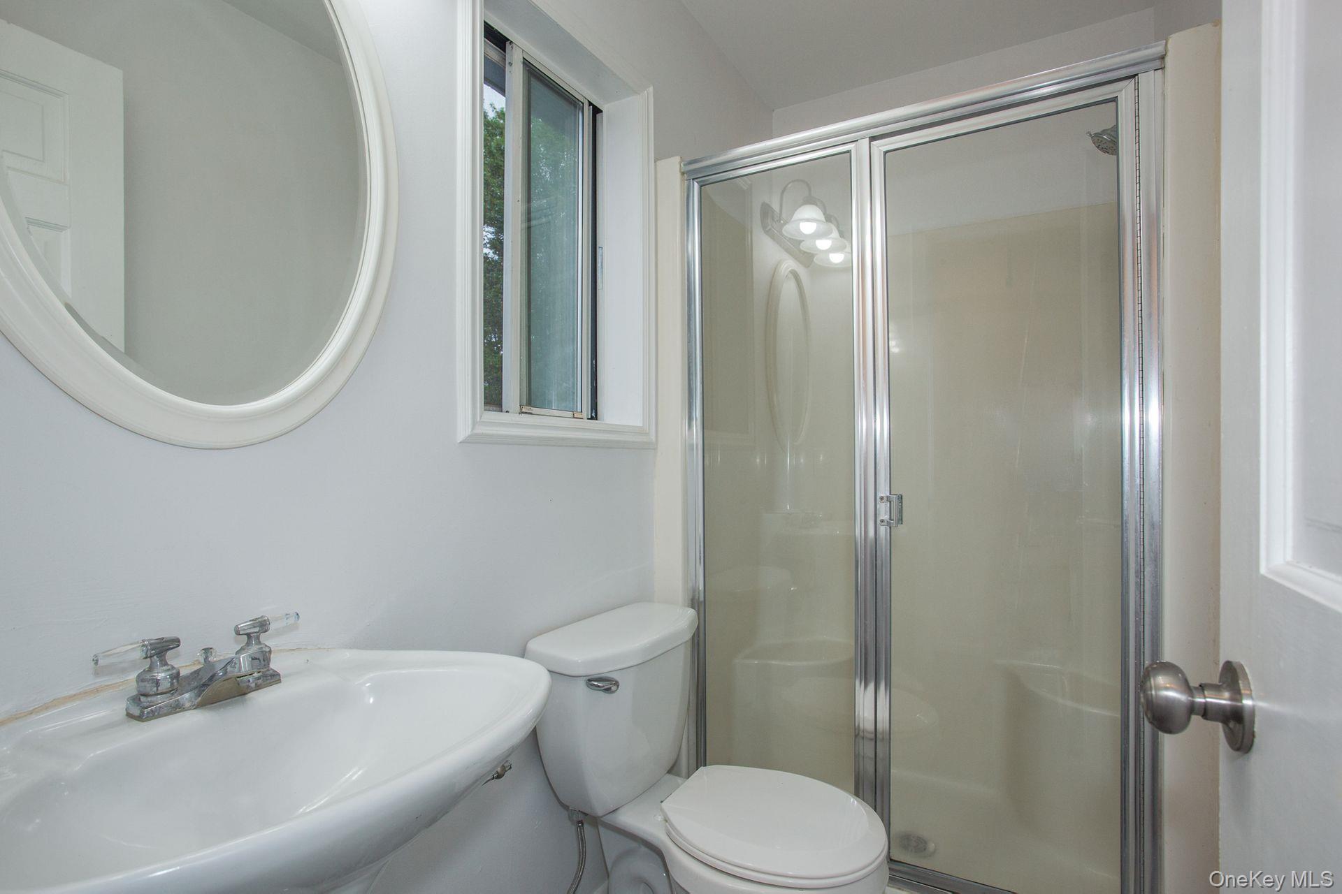 12 North Ridge Road Setauket, NY 11733 - Photo 14 of 34 a bathroom with a toilet a sink and a mirror