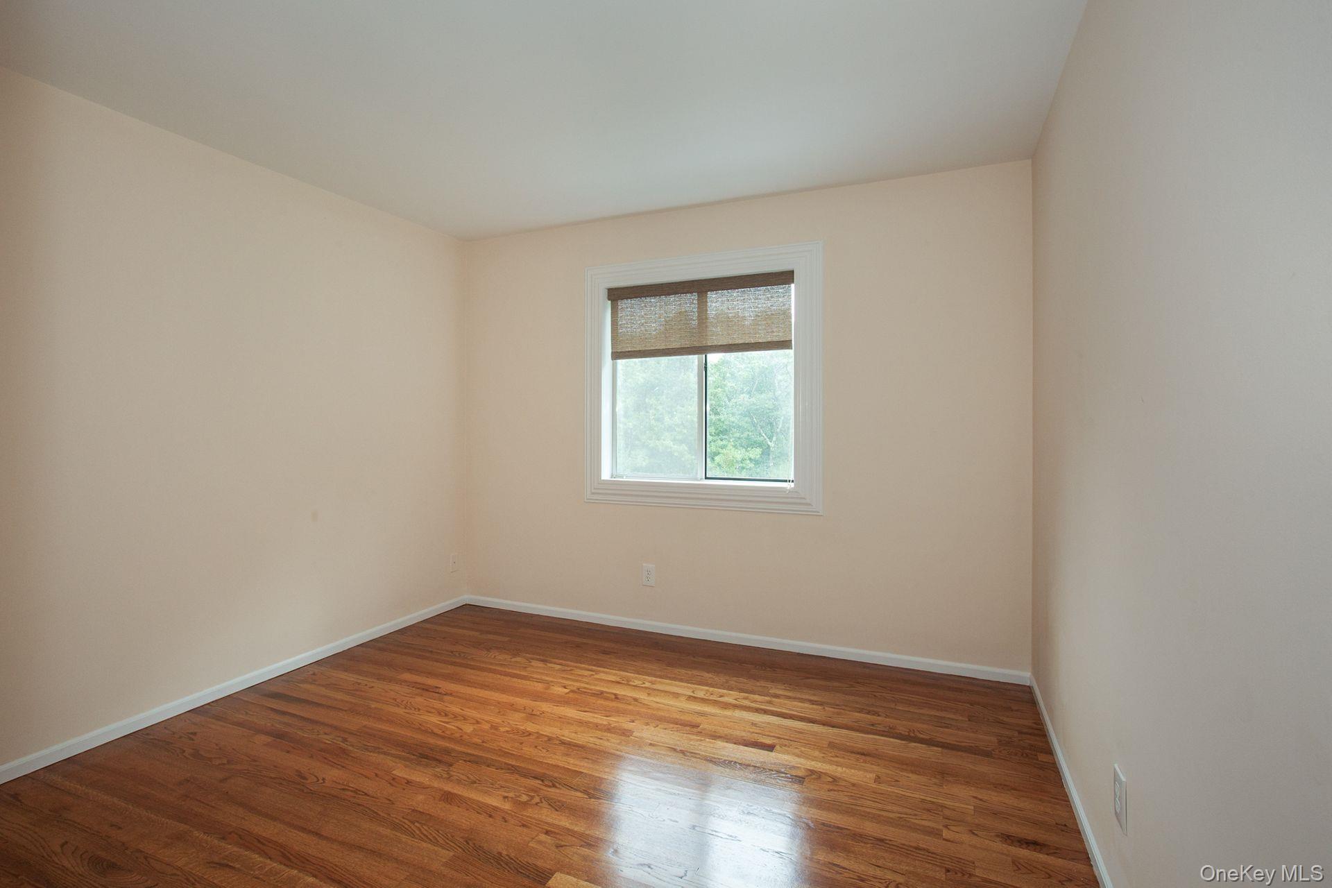 12 North Ridge Road Setauket, NY 11733 - Photo 18 of 34 an empty room with wooden floor and windows