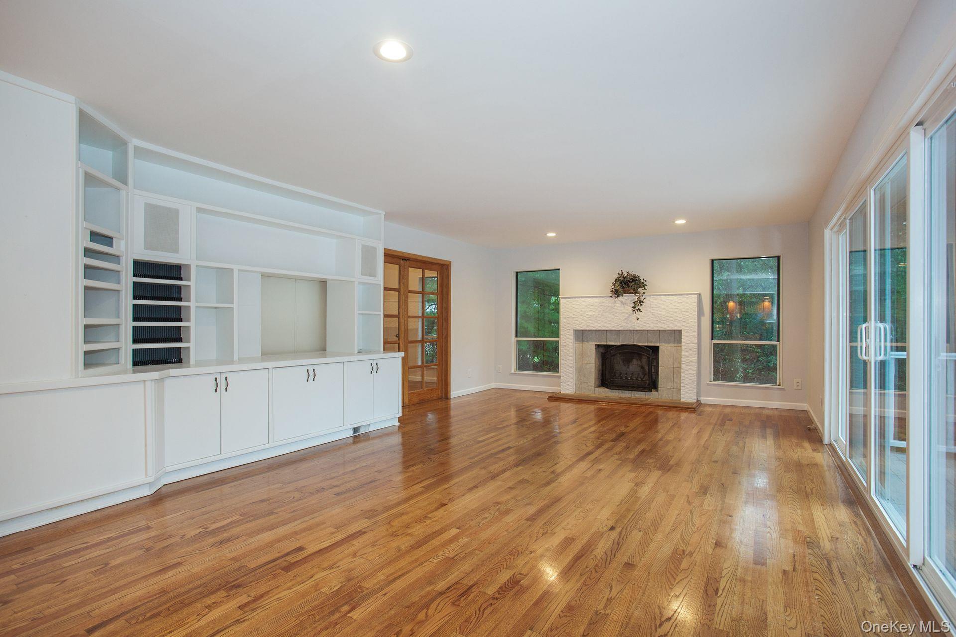 12 North Ridge Road Setauket, NY 11733 - Photo 27 of 34 an empty room with wooden floor fireplace and windows