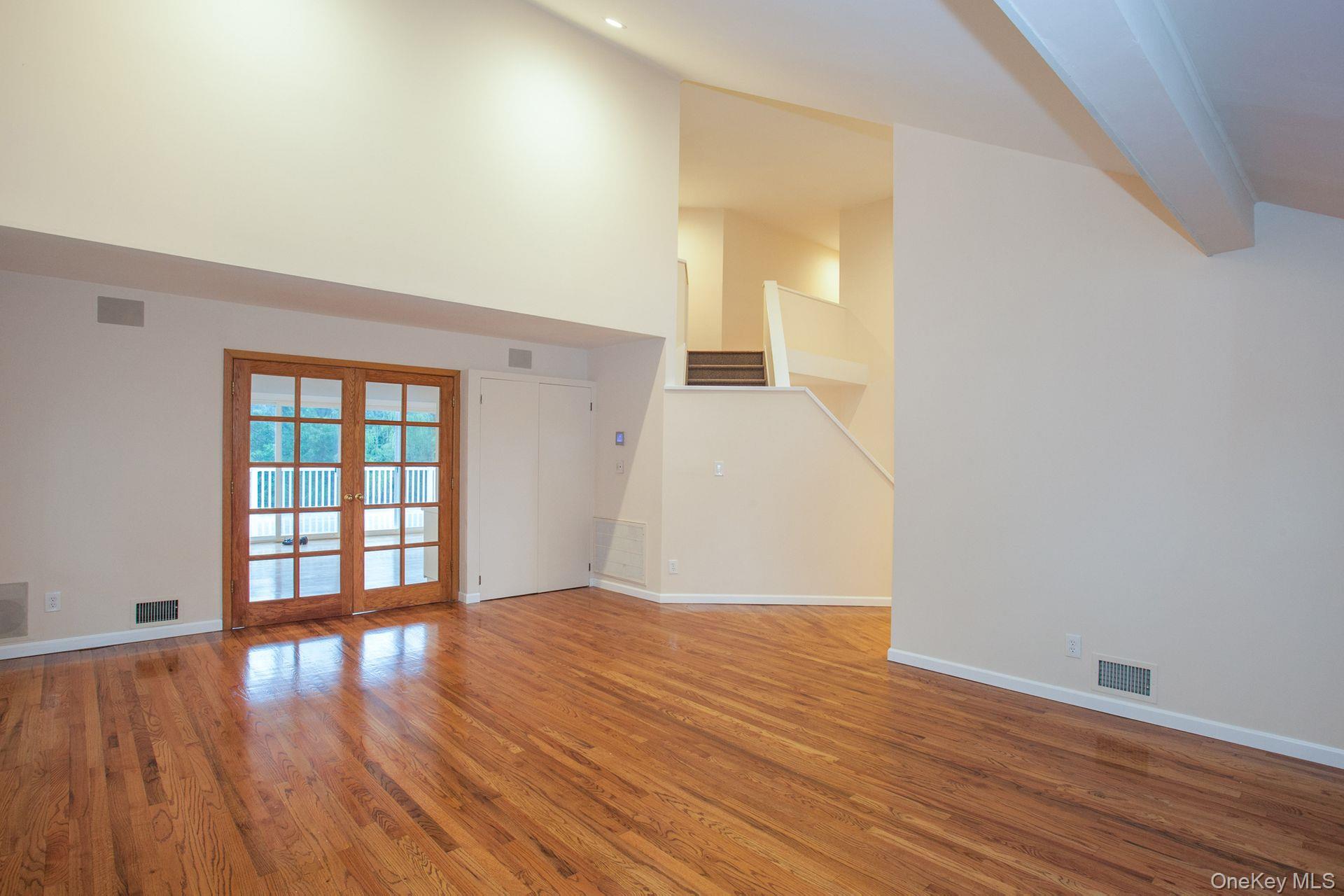 12 North Ridge Road Setauket, NY 11733 - Photo 6 of 34 a view of an empty room with wooden floor and a window