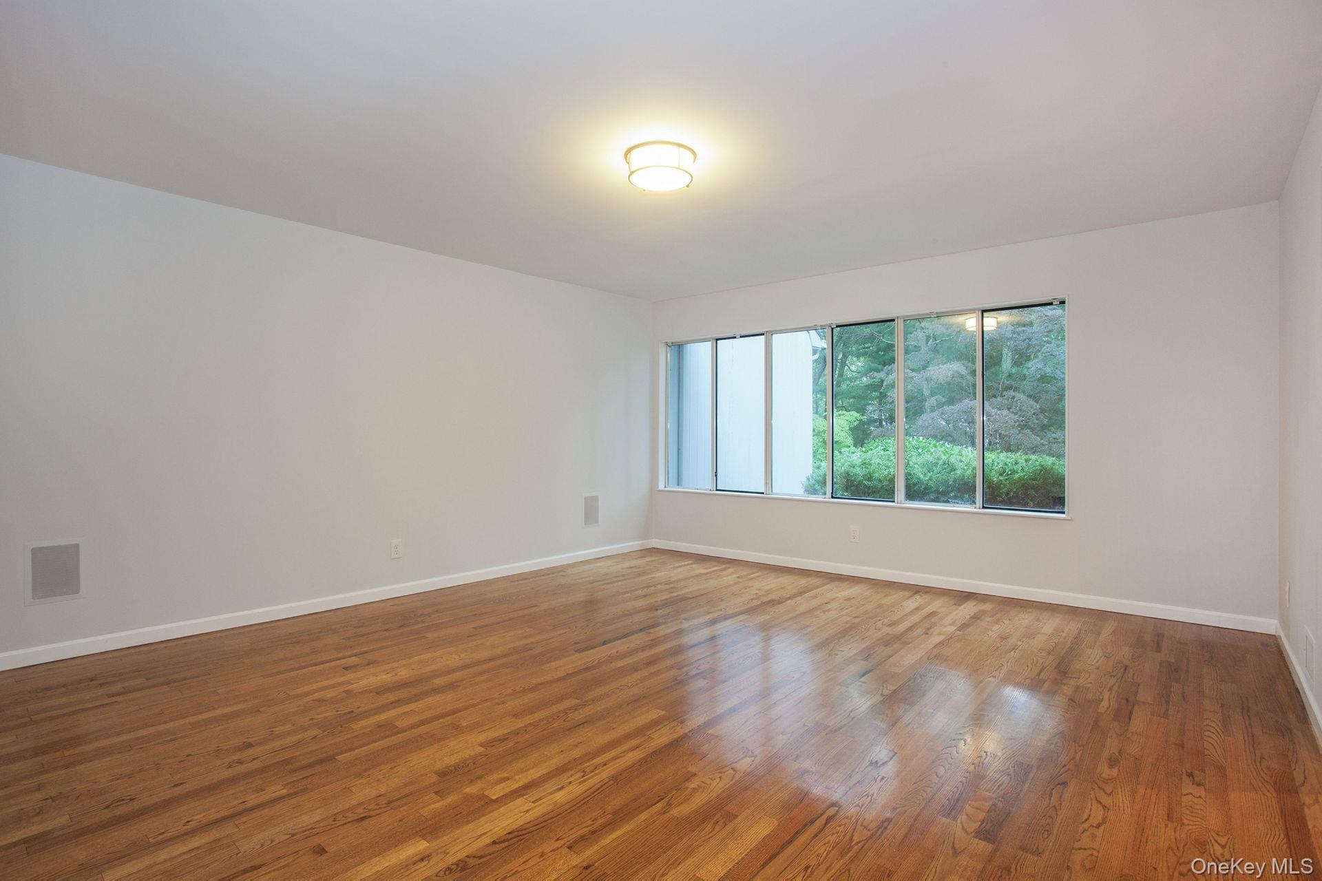 12 North Ridge Road Setauket, NY 11733 - Photo 8 of 34 a view of an empty room with wooden floor and a window