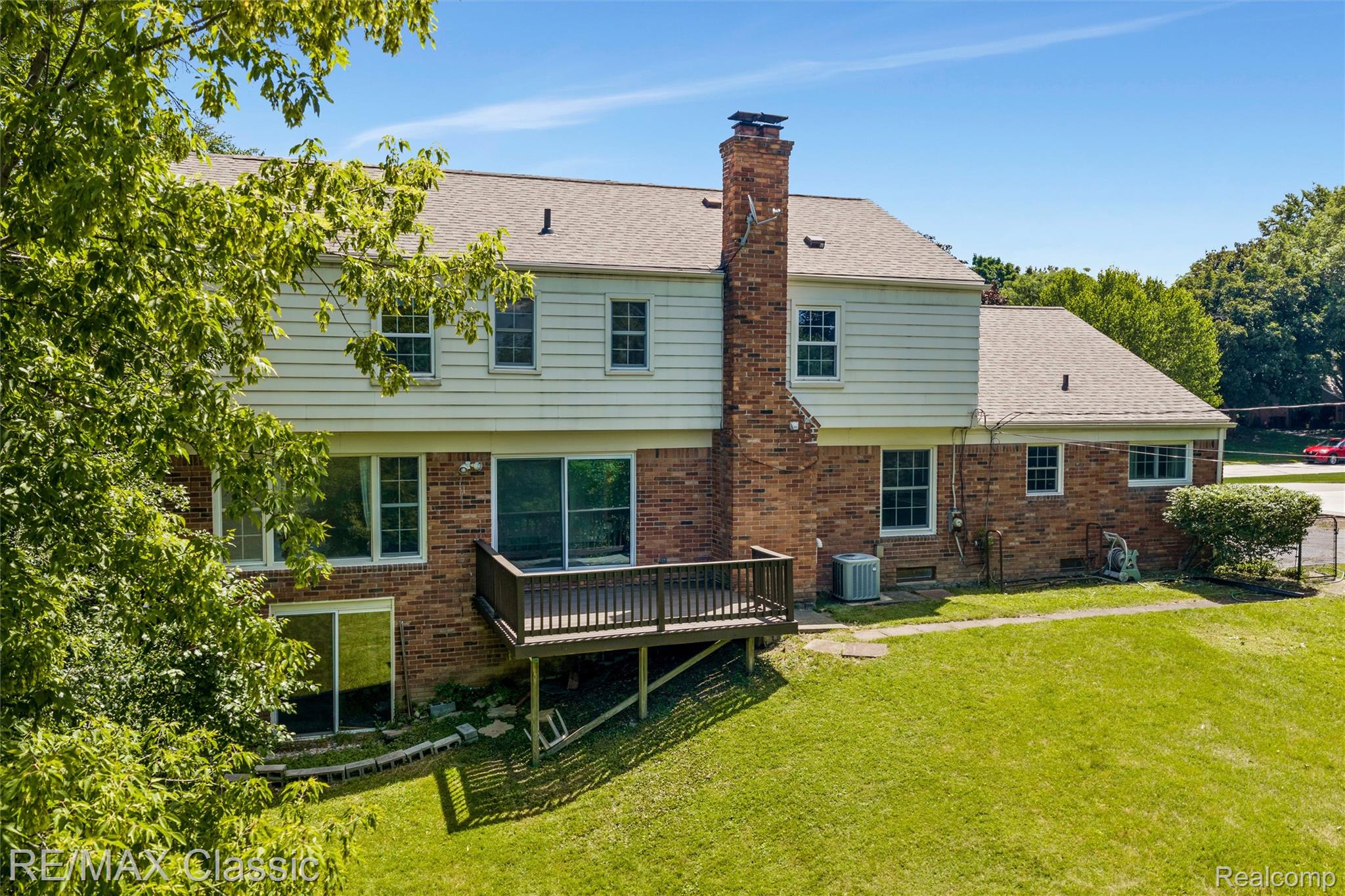 4268 Covered Bridge Road Bloomfield Hills, MI 48302 - Photo 30 of 35 Brick and siding exterior featuring multiple windows and a prominent chimney