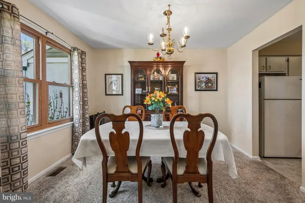 a view of a dining room with furniture a chandelier and wooden floor