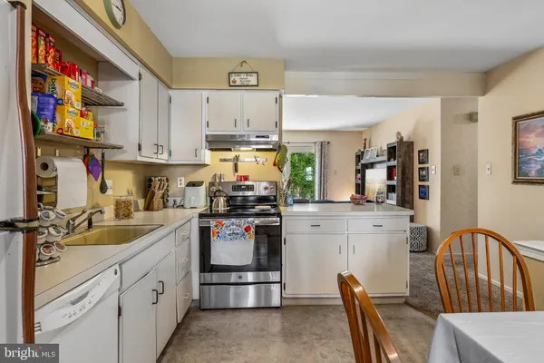 a kitchen with stainless steel appliances granite countertop a stove a sink dishwasher and cabinets